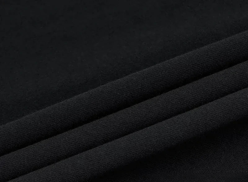 Macro of the folded black cotton the set is printed on, raking light across the folds