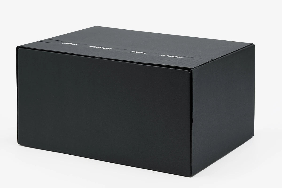 The closed black gift box in three-quarter view, its seal tape printed pidan HEADACHE